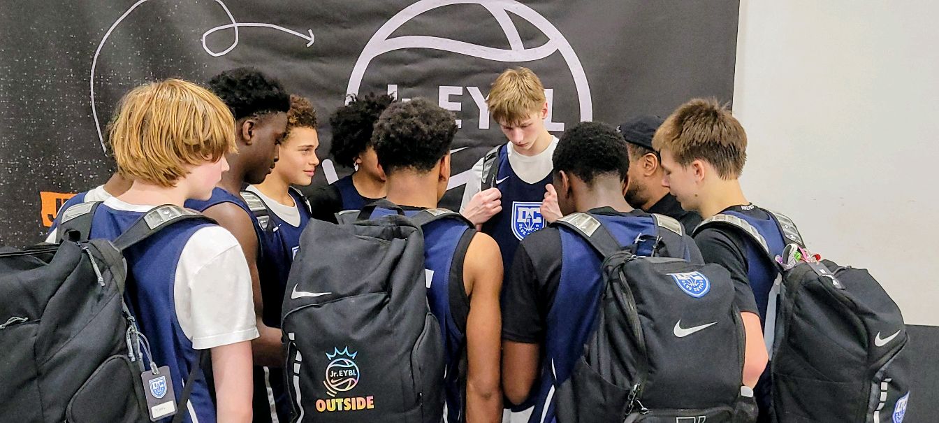 DC Blue Devils boys athletes gathered in a team huddle